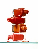 Close-up of open nail polish bottles against white background