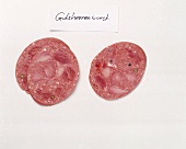 Slices of sausages on white background