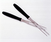 Close-up of two meat forks on white background