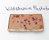 Slice of wild boar pate on white background