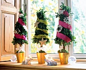 Three decorated Christmas trees on window sill