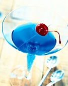 Close-up of blue curacao cocktail with vodka and cherry on top