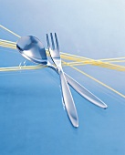 Besteck, Still  Gabel und Messer auf rohen Spaghetti, Spaghetti-Set