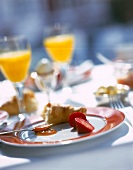 Croissant, egg, jam, strawberry and orange juice on plate