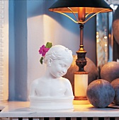 Alabaster Mädchenbüste neben Steinkugel unter Lampe