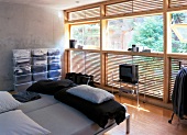Functionally furnished room with bed, glass timber louvre window