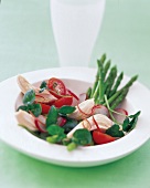 Salad with chicken fillet pieces, green asparagus, watercress and tomatoes on plate