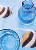Wasserglas mit Karaffe auf Fischdecke