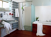 View of bathroom with tropical wooden floor, bathtub, shower and sink