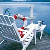 Weißer Parkstuhl und Klapp-Tisch mit Espresso-Gedeck,  am See
