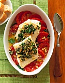 Salmon tomato fish garnished with pine nuts in serving dish, overhead view