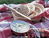 Rosmarin-Fladenbrot und Bohnenmus auf einer Decke im Freien, Messer