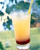 Glass of tequila sunrise with grenadine syrup, lemon juice and orange juice