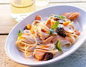 Spaghetti prepared with morel sauce and salmon in serving dish