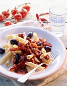 Close-up of penne with chilli garlic sauce and olives on plate