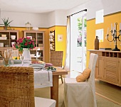 View of dining room with yellow walls and oak wood furniture