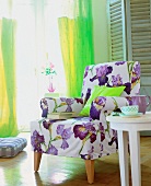 Purple and white floral pattern armchair and wooden floorings in living room