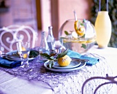 Table decorated with purple table cloth, turquoise dishes, punch and lemon