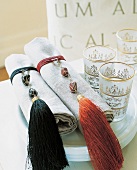 Napkin rings decorated with pearl and tassel beside teacups