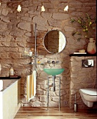 Bathroom with stone wall, bath tub, basin and wall mirror