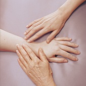 Hände unterschiedlichen Alters auf farbigem Untergrund, Frauenhände