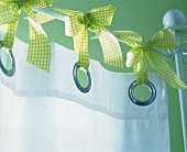 Close-up of finished curtain with green ribbons on green wall