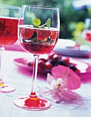 Sparkling wine with raspberry syrup and mint leaf in wine glass