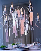 Candle chandelier with glass prisms hanging next to names of all guest