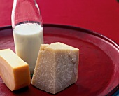 zwei Stück Käse und eine halbvolle Flasche mit Milch