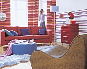 Wohnzimmer im Stil der 70er, Pop-Art Gestreifte Vorhänge und rotes Sofa.