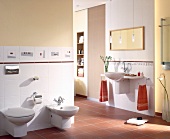 White tiled bathroom with washbasin, bidet and toilet