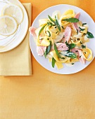 Lemon pasta with salmon served on plate, overhead view