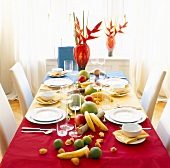 Table laid with white dishes, and fruits decorations