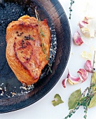 Close-up of rump steak with oil, black pepper and garlic in pan