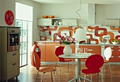 Küche in Orange und Weiß mit rundem Esstisch