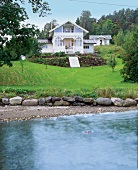 großes Sommerhaus mit Veranda am Ufer eines Fjordes in Norwegen