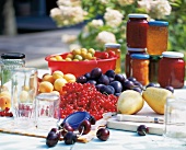 Summer fruits, jams, jellies and empty jars on table