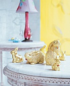 Kleine Häschen aus Porzellan, goldig bemalt, auf einem Tisch