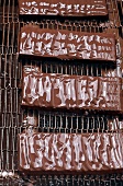 Mit Kuvertüre überzogene Schokolade auf Metallgitter