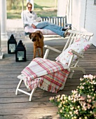 Blanket and pillow on deck chair from white wood