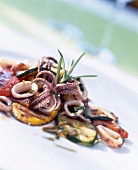 Close-up of marinated grilled vegetables with fried calamari on plate