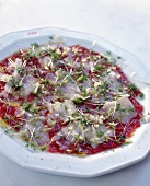 Close-up of beef carpaccio with parmesan cheese and cress on plate