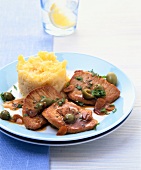 Steak with beans, olives and mashed potatoes on plate