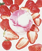 Erdbeeren liegen um eine pink weiße Kugel herum