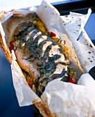 Close-up of salmon trout stuffed with thyme bay and garlic in parchment