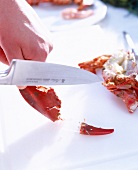 Close-up of removing lobster meat from shell with knife
