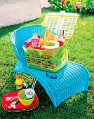 Gefüllter Picknickkorb auf blauem Stuhl aus Kunststoff,Melamingeschirr