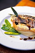 Close-up of sea bass with mashed potatoes and snow peas on plate