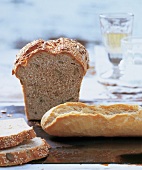Close-up of mixed seed bread and baguette on wooden table