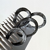Close-up of hair curls with foam between comb on white background